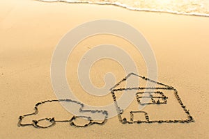 A car and a house drawn by hand on the beach sand in Sunny day.