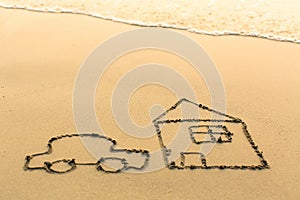 Car and a house drawn on the sand beach