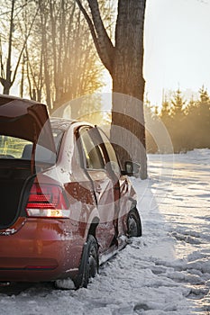 Car and ice on the winter road. The car had an accident in the winter, crashed into a tree and slid into a ditch on the