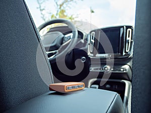 Car ignition key on the armrest in the interior of a modern car.