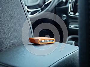 Car ignition key on the armrest in the interior of a modern car.