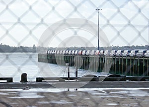 Car imports on wharf viewed through fencing at Auckland, New Zealand, NZ photo