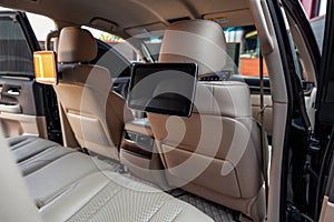 Car inside. Multimedia screens or TV displays for rear passenger seats. Luxury car interior with leather seats