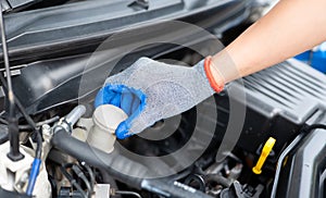Car inspection and maintenance concept. Man checking brake fluid in engine room. Check car brake fluid for safe travel. Car