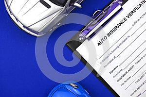 Car insurance claim form with car toy on the table and office desktop. Protection from accidents concept. Top view photo