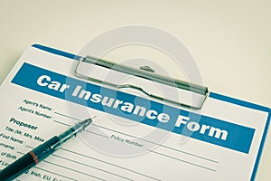 Car Insurance Claim Form or Insurance Document and Pen at Left Frame in Vintage Tone