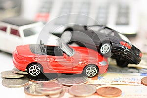 Car insurance concept with toy cars, car key, coins and bills
