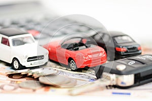 Car insurance concept with toy cars, car key, coins and bills