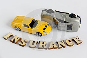 Car insurance isolated on white background with wooden letters toy car crash