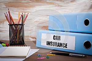 Car Insurance, Office Binder on Wooden Desk. On the table colored pencils, pen, notebook paper