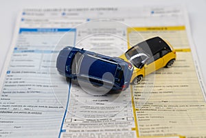 Car insurance report following an accident concept with toy cars on accident statement