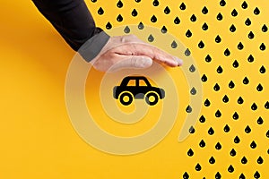 Car insurance, safety and care concept. Hand sheltering a automobile from rain