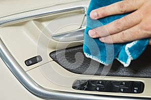 Car interior detailing moving hand of a man is cleaning a door handle of the car