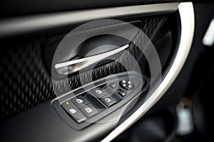 Car interior details of door handle, windows controls and adjustments. Car window controls and details photo