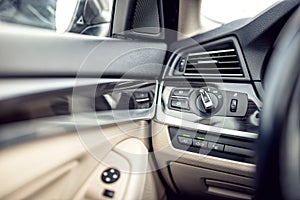 Car interior with leather and premium details. Headlights adjustment control and cockpit details