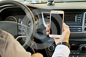 Car interior with male driver sitting behind the wheel, soft sunset light. Luxurious vehicle dashboard and electronics.