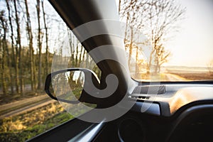 Car interior at sunrise on a forest road. Traveling with car concept . Car insurance concept