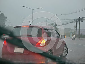 A car with its signal light on carefully making a U-turn in a heavy rain