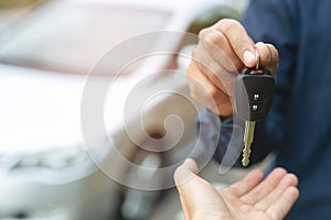 Car key, businessman handing over gives the car key to the other woman