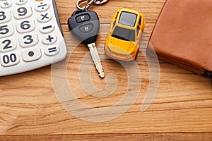Car key with calculator on wood background