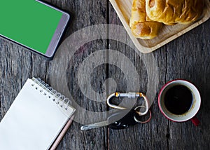 Car key and coffee cup Tasty buns and mobile phone  notepad on wood table backgrounds above