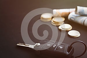 Car key and coins on black background, concept photo for car finance industry