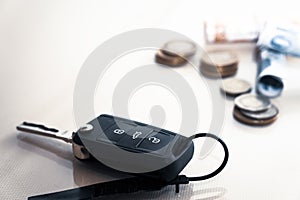 Car key and coins on white background, concept photo for car finance industry