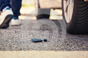 Car key fall on the asphalt road. Driver lost his vehicle keys and walks away photo