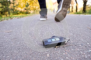 Car key fall on the asphalt road, driver unlucky man lost his vehicle keys and walks away, misfortune concept
