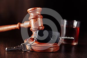 Car key, judge gavel and bottle of alcohol with glass close-up. Drunk driving concept