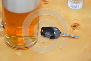 Car key lies on a table near the glasses of alcohol