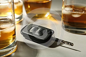 Car key near glasses of alcohol on table. Dangerous drinking and driving