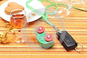 Car key and overturned model vehicle with glass of wine