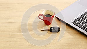 Car key and Red coffee cup and labtop on wood table backgrounds