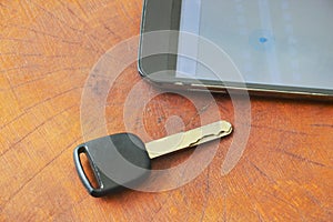 car key and smart phone opened map on table