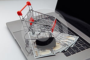 Car keys with dollar banknotes and shopping cart on keyboard. Online purchase car concept