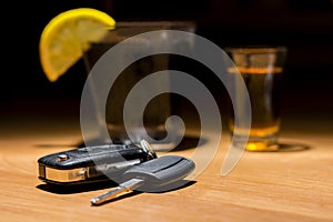 Car keys laid on the bar beside cocktail and whiskey