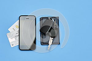 Car keys, mobile phone and credit cards on blue