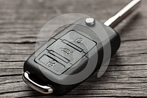 Car keys with remote control alarms on wooden background.