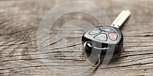 Car keys with remote control alarms on wooden background. Copy space for text.