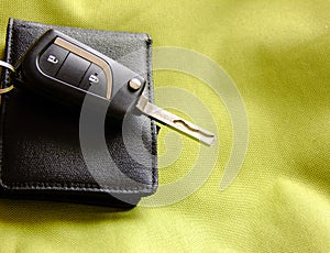 Car Keys and Wallet on greenish Textile Background