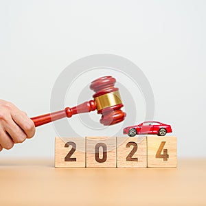 Car Law, Insurance, auto Tax, Auction and Bidding concepts. 2024 year block with crashed small toy car models with Judges gavel on