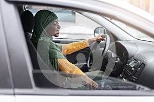 Car Leasing Concept. Happy Black Religious Woman In Hijab Driving Modern Vehicle