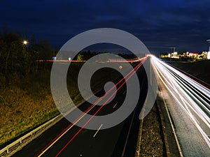 Car light trail on a free way in two directions. Dark blue sky. Transportation and commute concept