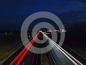 Car light trail on a free way in two directions. Dark blue sky. Transportation and commute concept