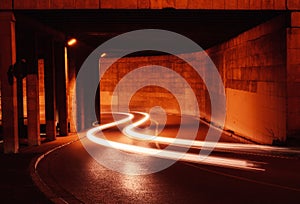 Car light trail under a warm bridge in Catalonia. Urban movement and transportation.