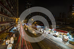 Car light trails in Yau Ma Tei Wholesale Fruit Market at night.