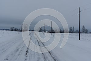 car lights on a snowy road in the countryside