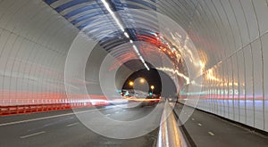 Car lights in a tunnel, city at night.