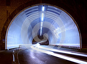 Car lights in a tunnel, city at night.